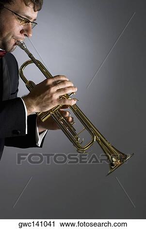 Side profile of a musician playing a trumpet View Large Photo Image Stock Image - Side profile of a musician playing a trumpet. Fotosearch