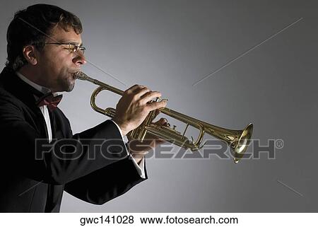 Side profile of a musician playing a trumpet View Large Photo Image Stock Photo - Side profile of a musician playing a trumpet. Fotosearch