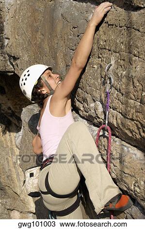 Female rock climber scaling a rock face View Large Photo Image Stock Image - Female rock climber scaling a rock face. Fotosearch