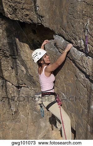 Female rock climber scaling a rock face View Large Photo Image Stock Image - Female rock climber scaling a rock face. Fotosearch