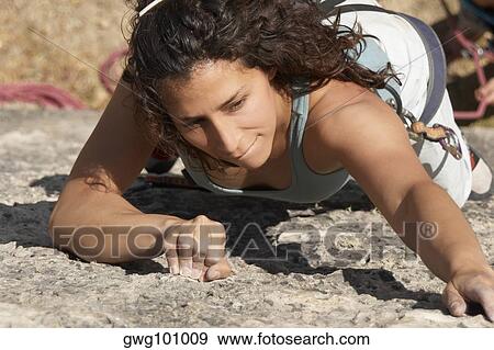 Female rock climber scaling a rock face View Large Photo Image Stock Photo - Female rock climber scaling a rock face. Fotosearch