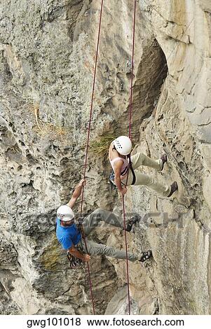 High angle view of a male and a female rock climber scaling a rock face View Large Photo Image Stock Photo - High angle view of a male and a female rock climber scaling a rock face. Fotosearch