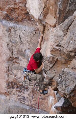High angle view of a male rock climber rappelling down a rock face View Large Photo Image Stock Image - High angle view of a male rock climber rappelling down a rock face. Fotosearch