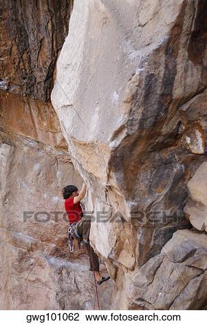 High angle view of a male rock climber scaling a rock face View Large Photo Image Stock Image - High angle view of a male rock climber scaling a rock face. Fotosearch