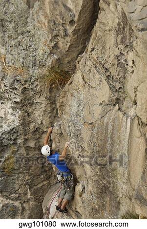 High angle view of a male rock climber scaling a rock face View Large Photo Image Stock Image - High angle view of a male rock climber scaling a rock face. Fotosearch