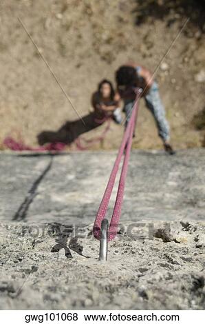 High angle view of a male rock climber scaling a rock with a female rock climber looking at him View Large Photo Image Stock Photo - High angle view of a male rock climber scaling a rock with a female rock climber looking at him. Fotosearch