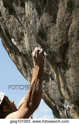 Male rock climber scaling a rock face View Large Photo Image Stock Image - Male rock climber scaling a rock face. Fotosearch