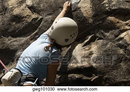 Rear view of a female rock climber scaling a rock face View Large Photo Image Stock Image - Rear view of a female rock climber scaling a rock face. Fotosearch