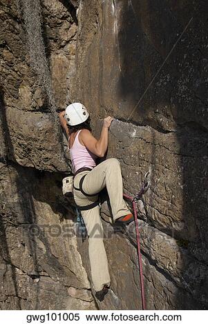 Rear view of a female rock climber scaling a rock face View Large Photo Image Stock Photography - Rear view of a female rock climber scaling a rock face. Fotosearch