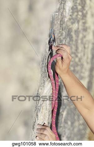 Rock climber hinging a rope in a quickdraw View Large Photo Image Stock Photo - Rock climber hinging a rope in a quickdraw. Fotosearch