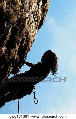 Silhouette of a female rock climber holding onto a rock with the help of a rope View Large Photo Image Stock Image - Silhouette of a female rock climber holding onto a rock with the help of a rope. Fotosearch