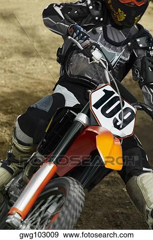 Close-up of a motocross rider riding a motorcycle View Large Photo Image Stock Photo - Close-up of a motocross rider riding a motorcycle. Fotosearch
