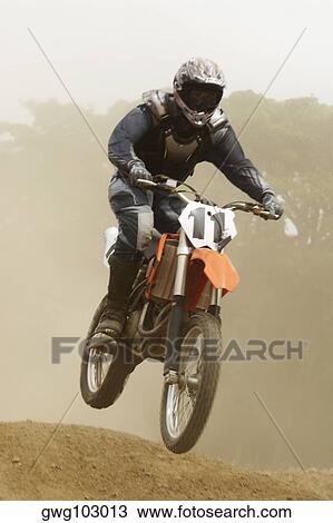 Low angle view of a motocross rider performing a jump on a motorcycle View Large Photo Image Stock Image - Low angle view of a motocross rider performing a jump on a motorcycle. Fotosearch