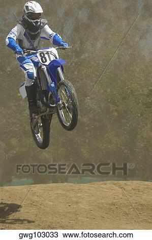 Low angle view of a motocross rider performing a jump on a motorcycle View Large Photo Image Stock Image - Low angle view of a motocross rider performing a jump on a motorcycle. Fotosearch