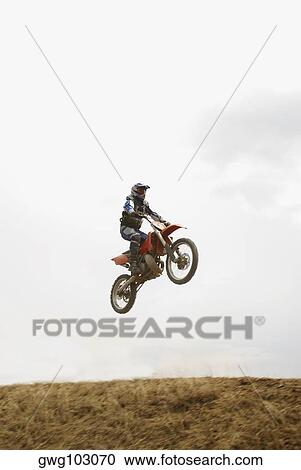 Low angle view of a motocross rider performing a jump on a motorcycle View Large Photo Image Stock Image - Low angle view of a motocross rider performing a jump on a motorcycle. Fotosearch