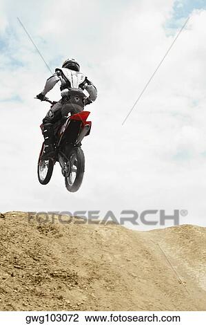 Low angle view of a motocross rider performing a jump on a motorcycle View Large Photo Image Stock Image - Low angle view of a motocross rider performing a jump on a motorcycle. Fotosearch