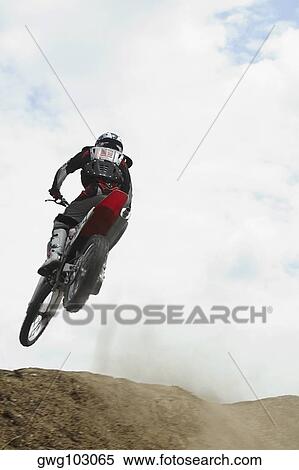 Low angle view of a motocross rider performing a jump on a motorcycle View Large Photo Image Stock Photography - Low angle view of a motocross rider performing a jump on a motorcycle. Fotosearch