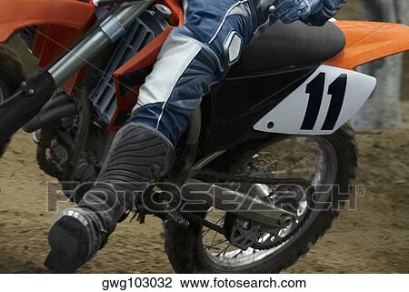 Low section view of a motocross rider riding a motorcycle View Large Photo Image Stock Image - Low section view of a motocross rider riding a motorcycle. Fotosearch