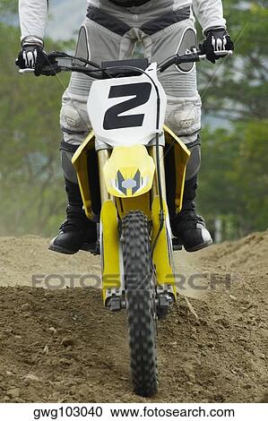 Stock Image - Low section view of a motocross rider riding a motorcycle. Fotosearch