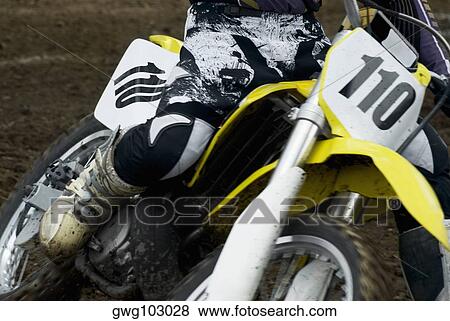 Low section view of a motocross rider riding a motorcycle View Large Photo Image Stock Photo - Low section view of a motocross rider riding a motorcycle. Fotosearch