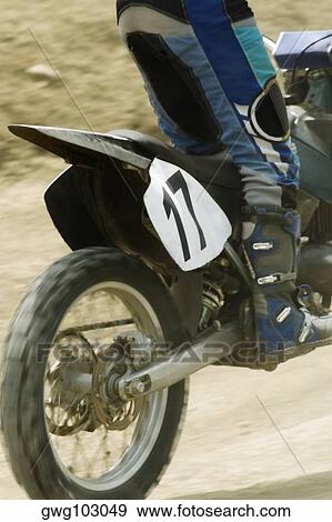 Low section view of a motocross rider riding a motorcycle View Large Photo Image Stock Photo - Low section view of a motocross rider riding a motorcycle. Fotosearch