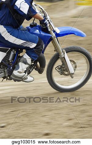 Stock Photography - Low section view of a motocross rider riding a motorcycle. Fotosearch