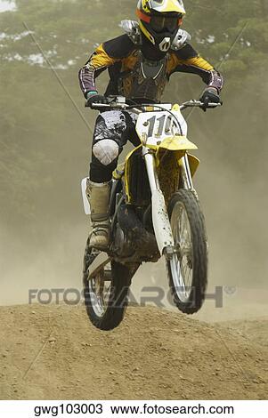 Motocross rider performing a jump on a motorcycle View Large Photo Image Stock Image - Motocross rider performing a jump on a motorcycle. Fotosearch