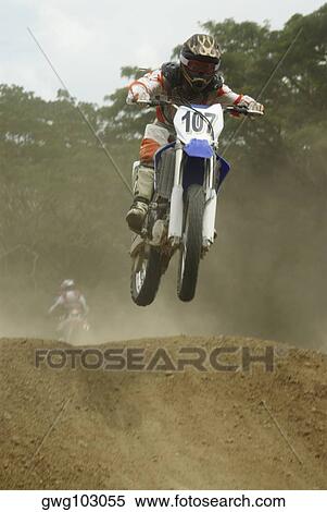 Motocross rider performing a jump on a motorcycle View Large Photo Image Stock Photography - Motocross rider performing a jump on a motorcycle. Fotosearch