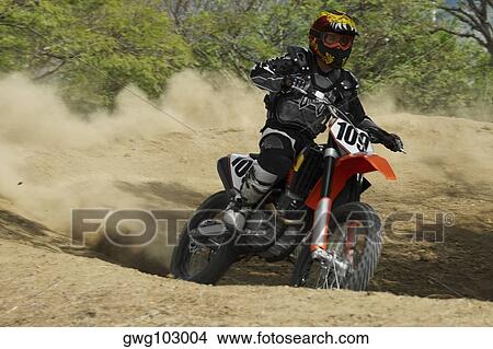 Picture - Motocross rider riding a motorcycle. Fotosearch