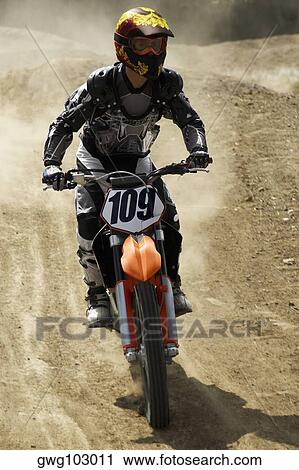 Stock Image - Motocross rider riding a motorcycle. Fotosearch