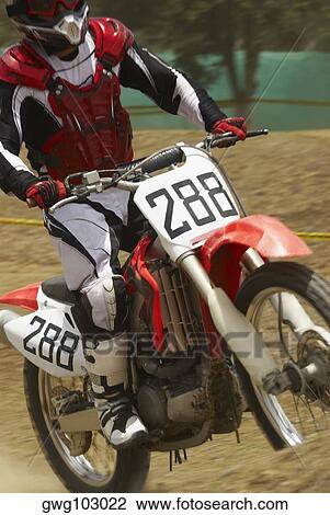 Stock Image - Motocross rider riding a motorcycle. Fotosearch