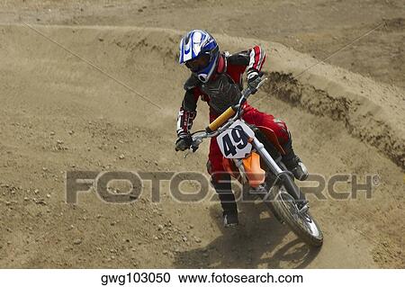 Stock Image - Motocross rider riding a motorcycle. Fotosearch