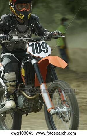 Motocross rider riding a motorcycle View Large Photo Image Stock Photography - Motocross rider riding a motorcycle. Fotosearch