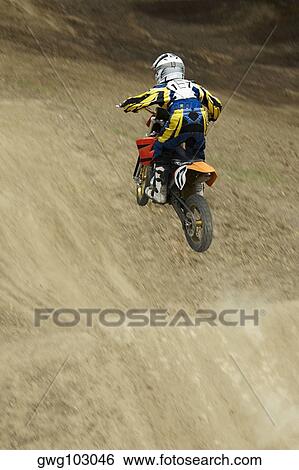 Rear view of a motocross rider performing jump on a motorcycle View Large Photo Image Stock Photograph - Rear view of a motocross rider performing jump on a motorcycle. Fotosearch