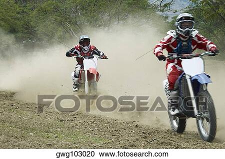 Two motocross riders riding motorcycles View Large Photo Image Stock Image - Two motocross riders riding motorcycles. Fotosearch