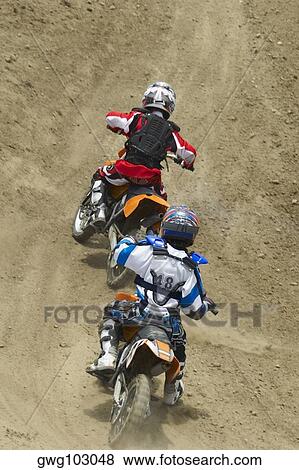 Two motocross riders riding motorcycles View Large Photo Image Stock Photo - Two motocross riders riding motorcycles. Fotosearch