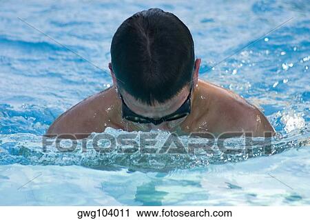 Stock Image - Close-up of a young man swimming in a swimming pool. Fotosearch