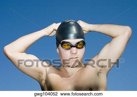 Close-up of a young man wearing a swimming cap View Large Photo Image Stock Image - Close-up of a young man wearing a swimming cap. Fotosearch