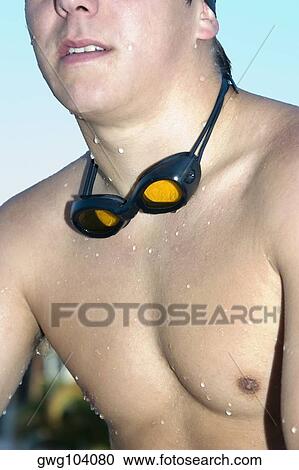 Stock Image - Close-up of a young man with swimming goggles around his neck. Fotosearch
