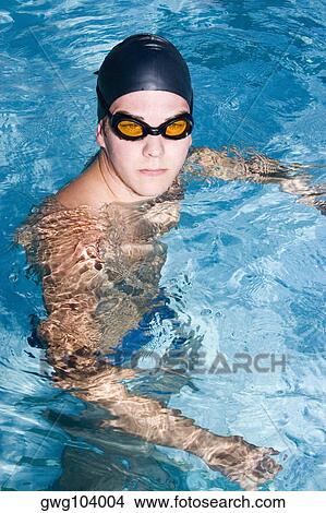 Picture - High angle view of a young man swimming in a swimming pool. Fotosearch