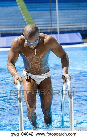 Mid adult man climbing a swimming pool ladder View Large Photo Image Stock Image - Mid adult man climbing a swimming pool ladder. Fotosearch