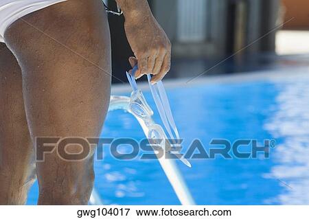 Mid section view of a mid adult man holding his swimming goggles View Large Photo Image Stock Photo - Mid section view of a mid adult man holding his swimming goggles. Fotosearch
