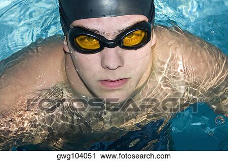Stock Image - Portrait of a young man in a swimming pool. Fotosearch