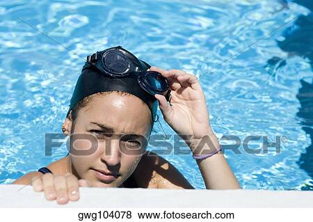 Portrait of a young woman gripping the edge of a swimming pool View Large Photo Image Stock Photo - Portrait of a young woman gripping the edge of a swimming pool. Fotosearch