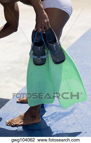 Side profile of a mid adult man holding a pair of flippers View Large Photo Image Stock Image - Side profile of a mid adult man holding a pair of flippers. Fotosearch