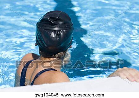 Side profile of a young woman leaning at the ledge of a swimming pool View Large Photo Image Stock Photography - Side profile of a young woman leaning at the ledge of a swimming pool. Fotosearch