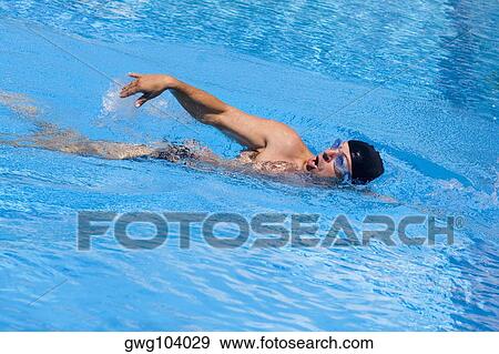 Young man swimming in a swimming pool View Large Photo Image Stock Photo - Young man swimming in a swimming pool. Fotosearch