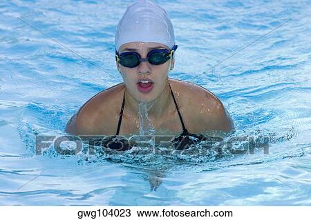 Young woman swimming in a swimming pool View Large Photo Image Stock Image - Young woman swimming in a swimming pool. Fotosearch
