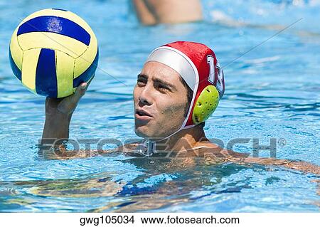 Close-up of a mid adult man playing water polo in a swimming pool View Large Photo Image Picture - Close-up of a mid adult man playing water polo in a swimming pool. Fotosearch