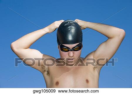 Close-up of a young man wearing a swimming cap View Large Photo Image Stock Photo - Close-up of a young man wearing a swimming cap. Fotosearch